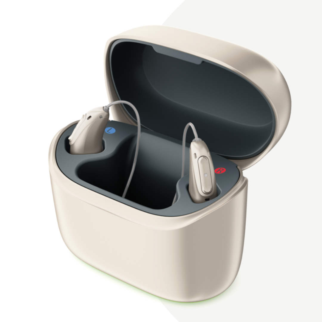 Phonak Charger Ease opened to reveal L50 and L90 Luminy hearing aids inside. The charger is compact and designed to securely hold and charge the hearing aids, which are neatly placed in their respective slots with indicators for left and right.